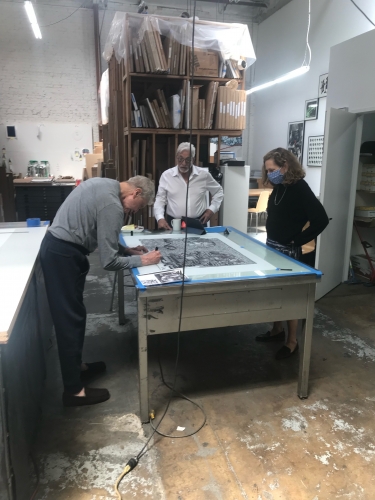 Derek Boshier signing his print at Cirrus with Cirrus founder Jean Robert Milant and LACMA print curator Leslie Jones, 2021